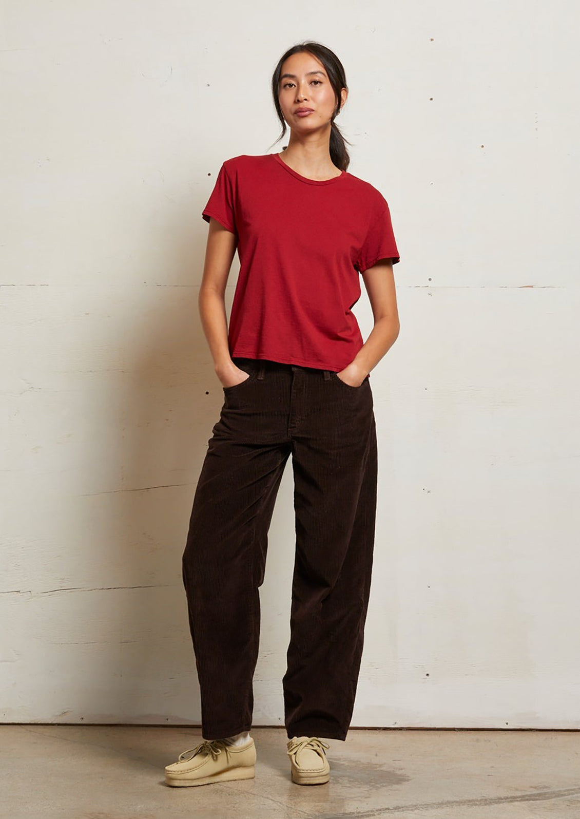 A woman wearing a short sleeve t-shirt in rich red color.