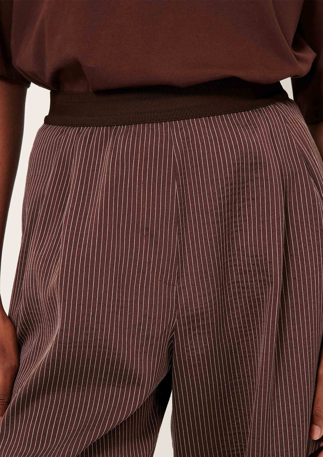 Brown pinstripe pants worn by a person.