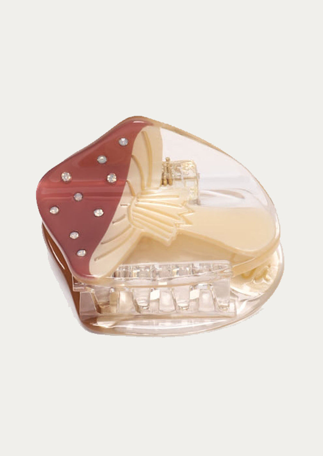 A hair claw shaped like a red capped mushroom with crystal detailing.