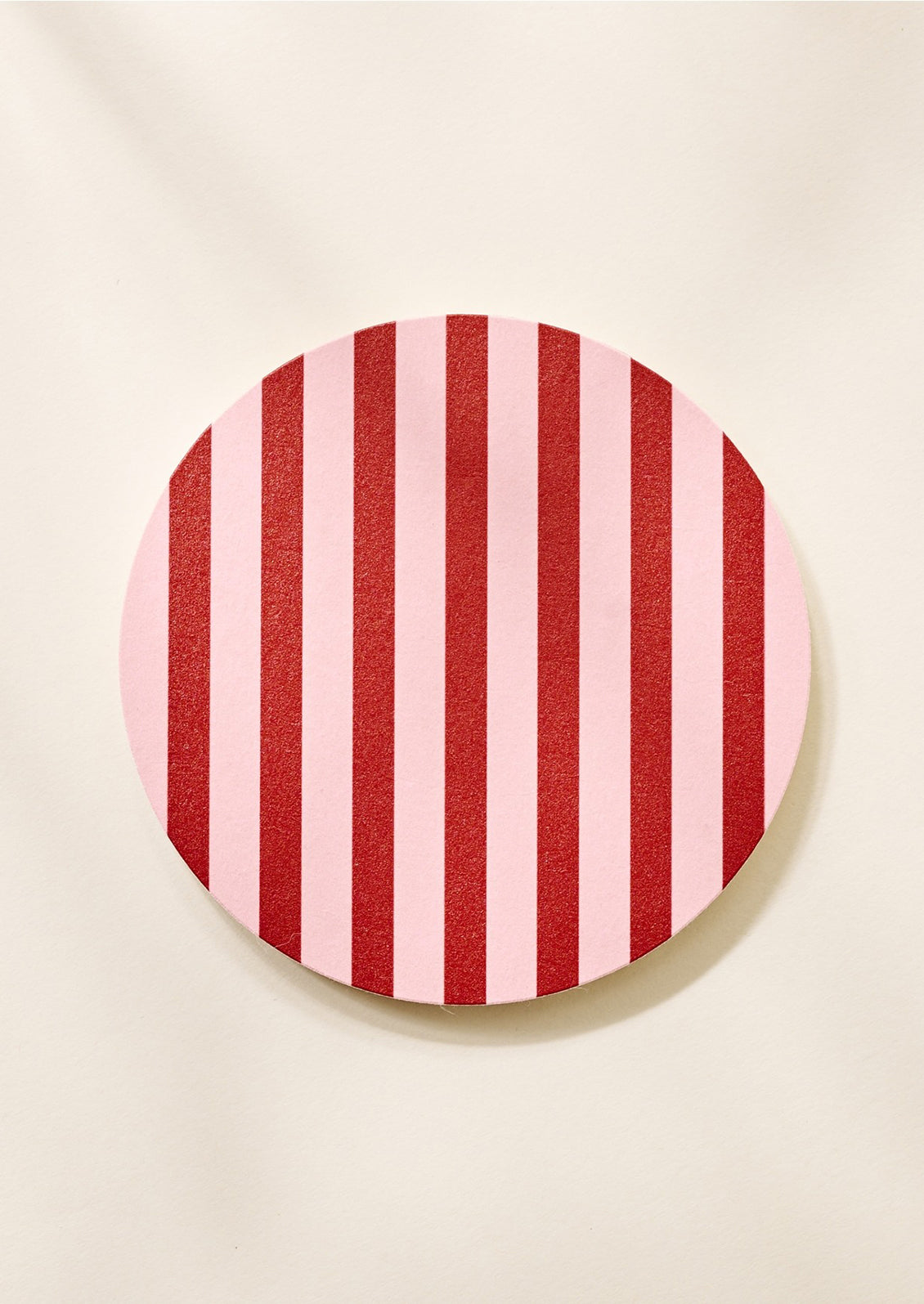 A set of coasters in pink and burgundy stripe.