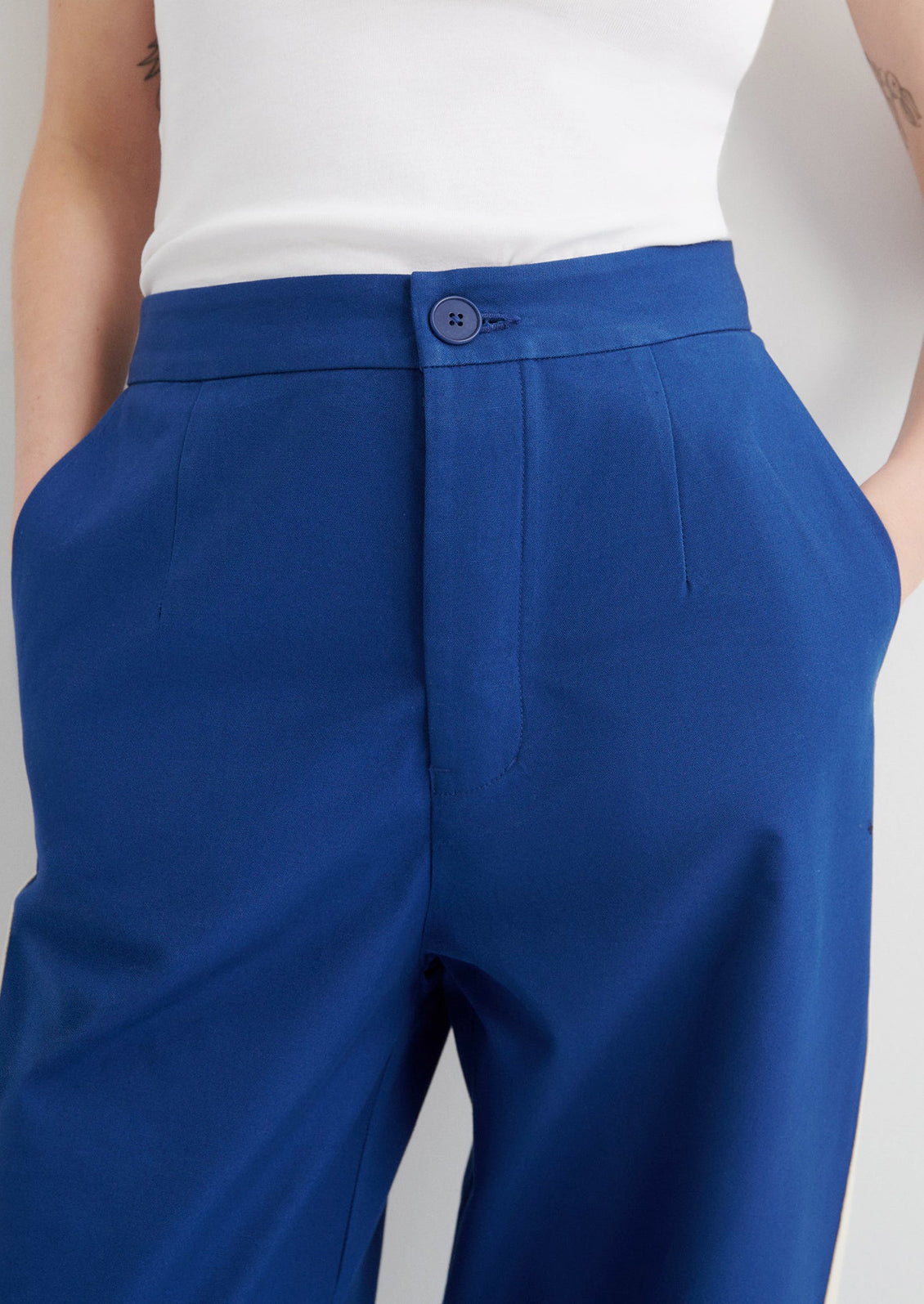 Blue pants worn by a person on a gray background