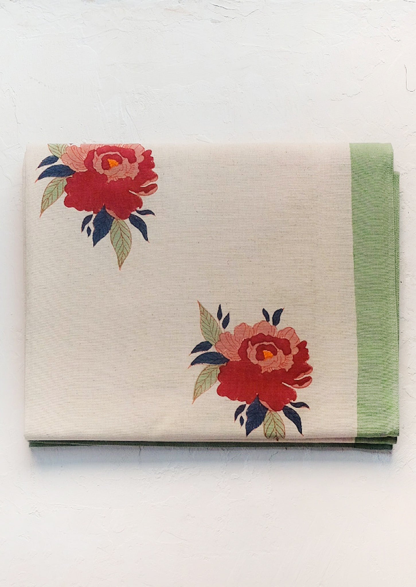 A floral print tablecloth with mint green border.