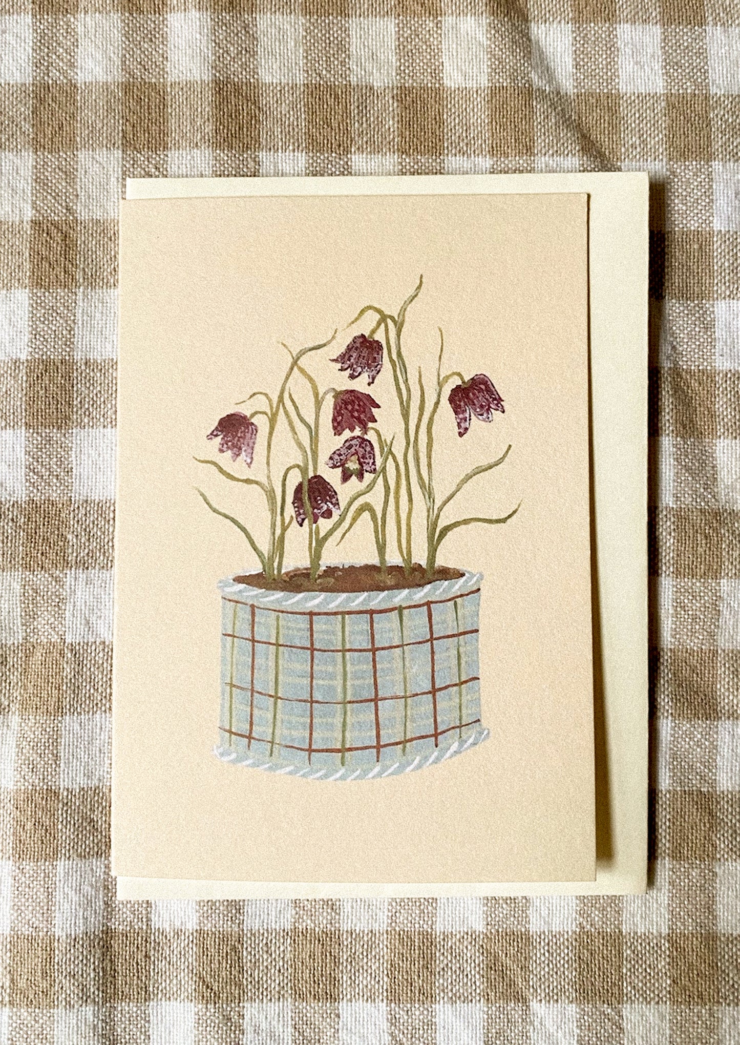 A mini greeting card in pale yellow with illustration of dancing snakeshead flowers in pot.