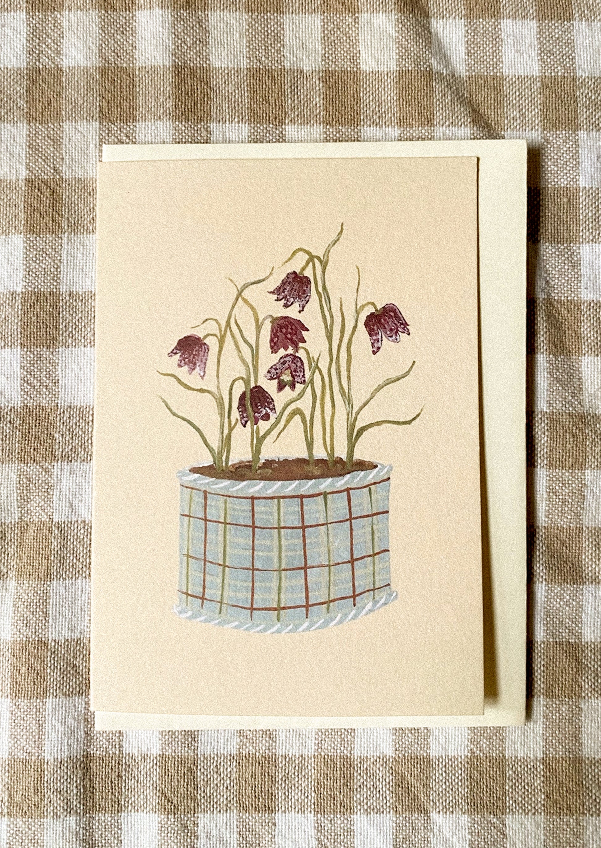A mini greeting card in pale yellow with illustration of dancing snakeshead flowers in pot.