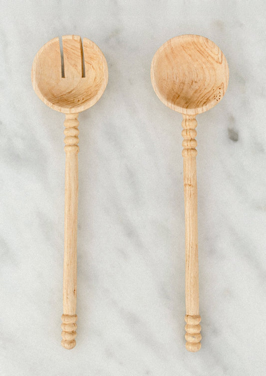 Two wooden spoons on a marble surface