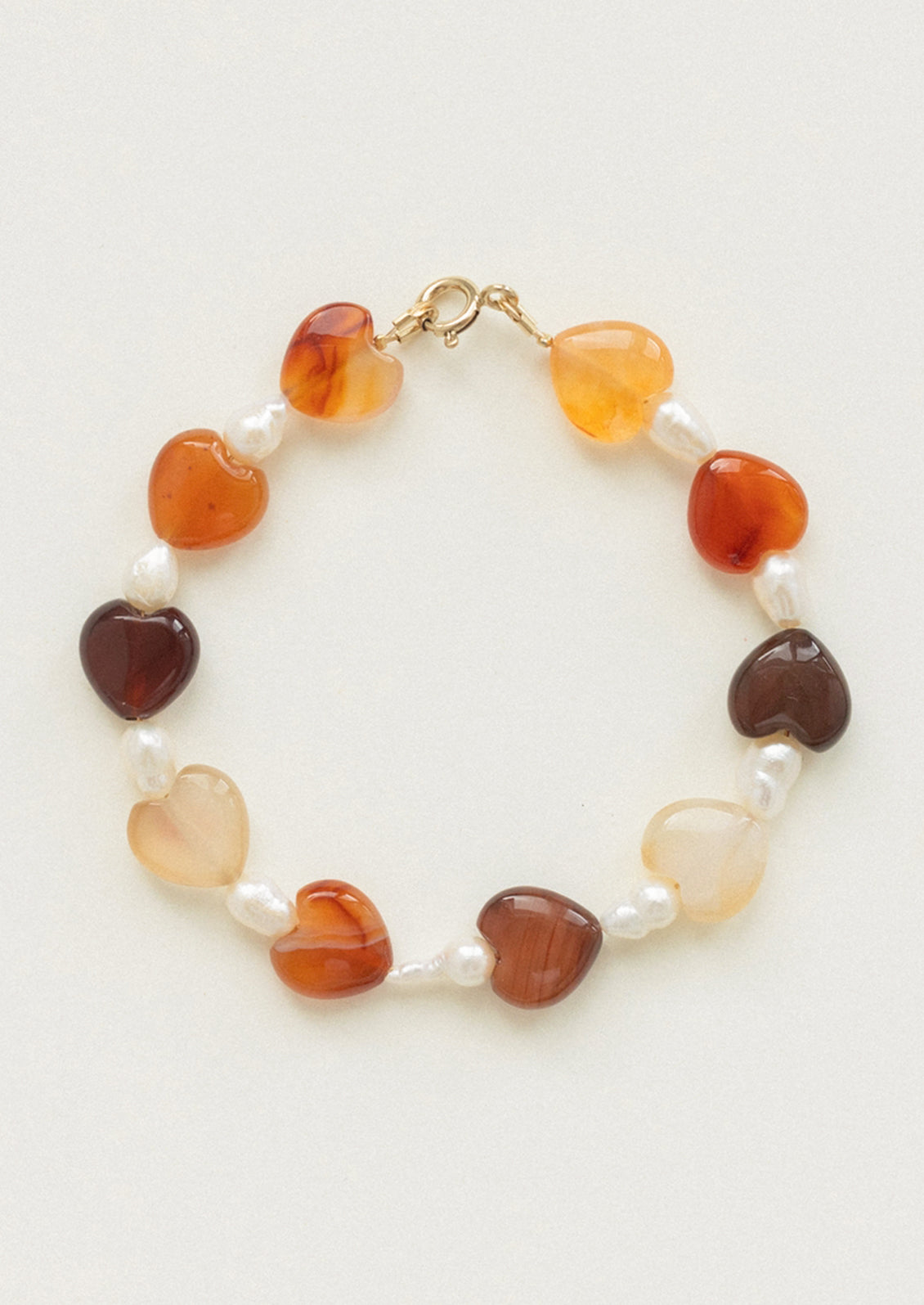 A beaded bracelet with alternating pearl and gemstone heart beads.