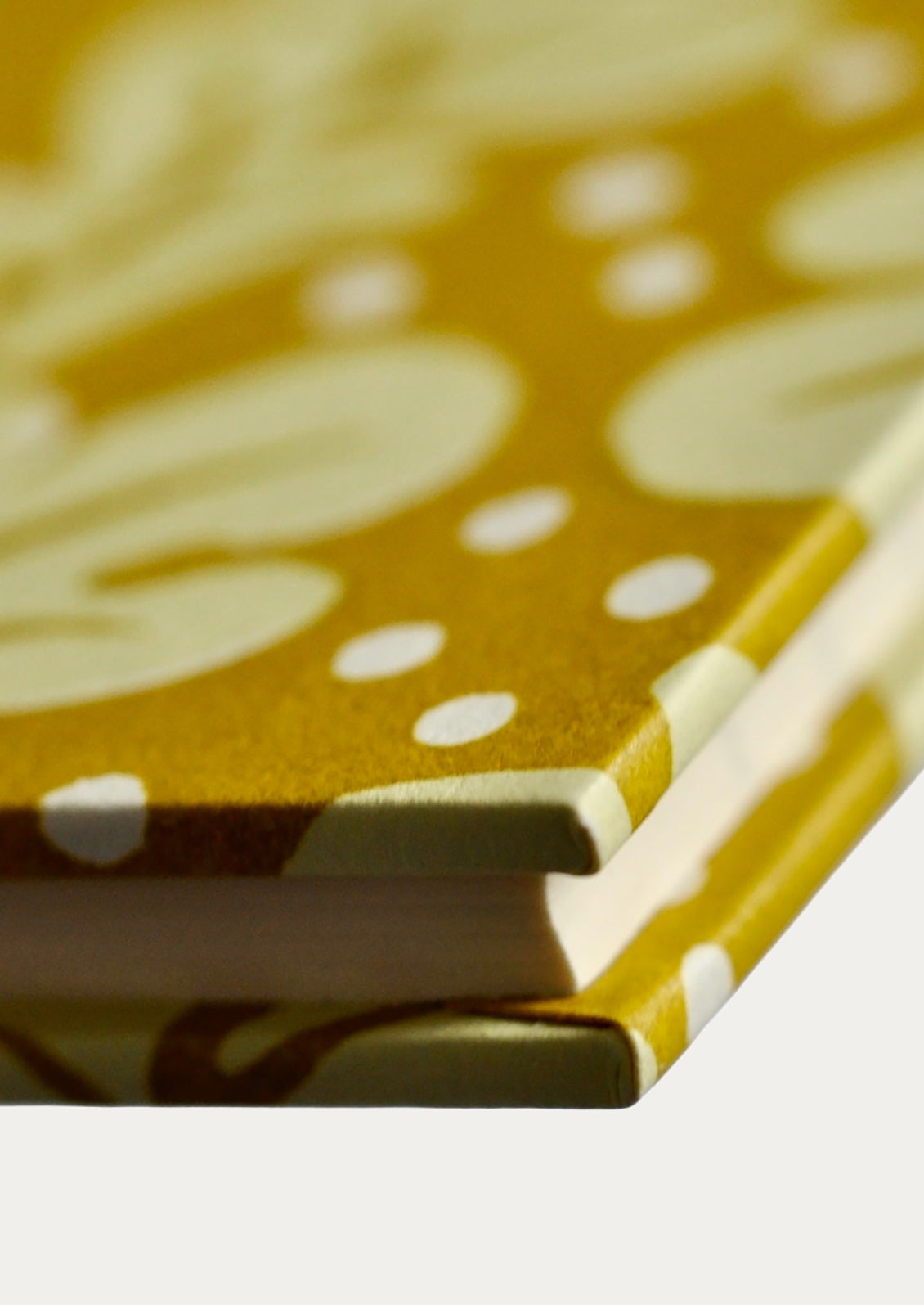 Close-up of a yellow notebook with white polka dots and brown abstract patterns.