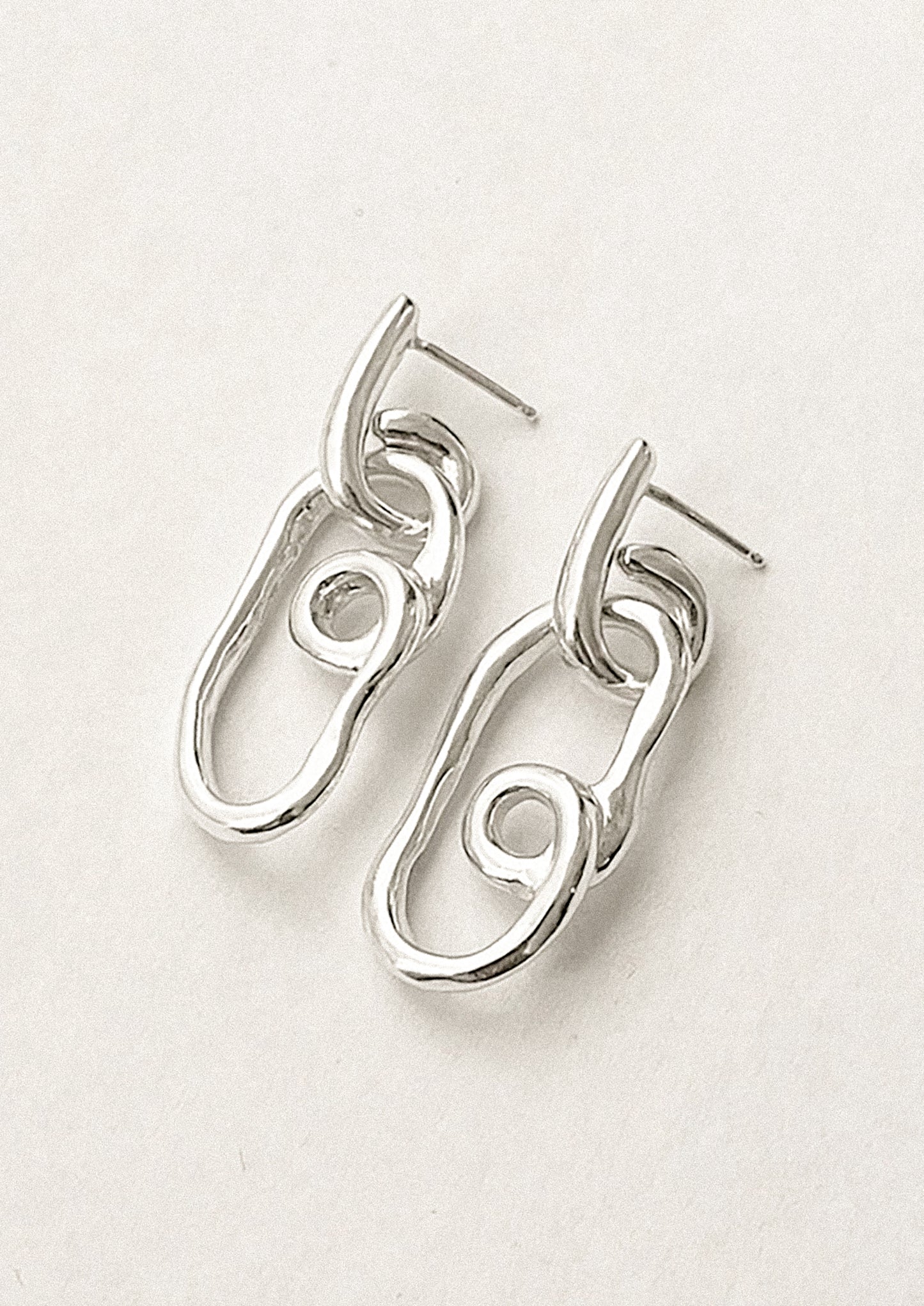 A pair of twisty sterling silver loop shaped earrings.
