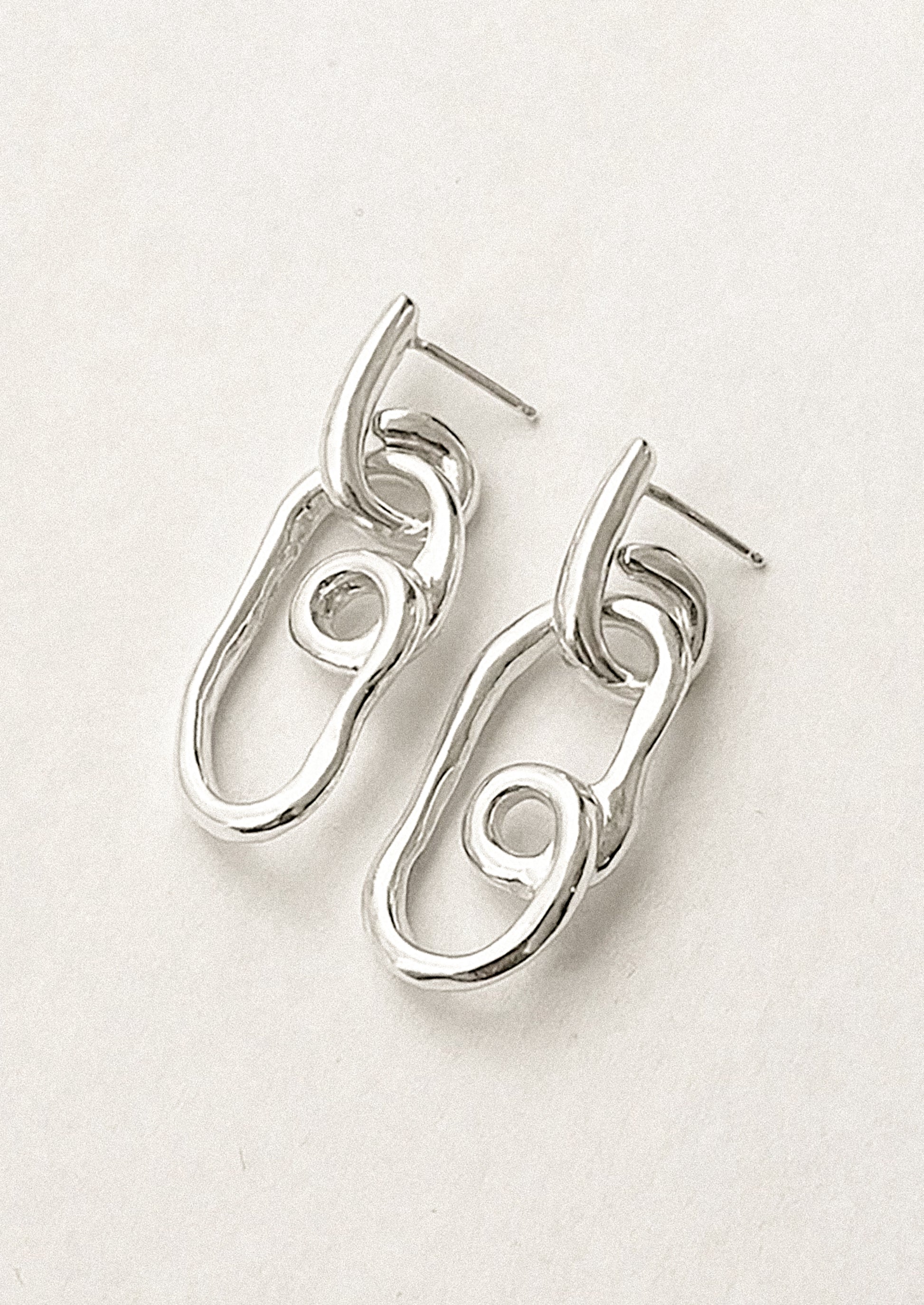 A pair of twisty sterling silver loop shaped earrings.