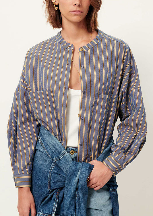 Person wearing a blue and yellow striped shirt with a white background