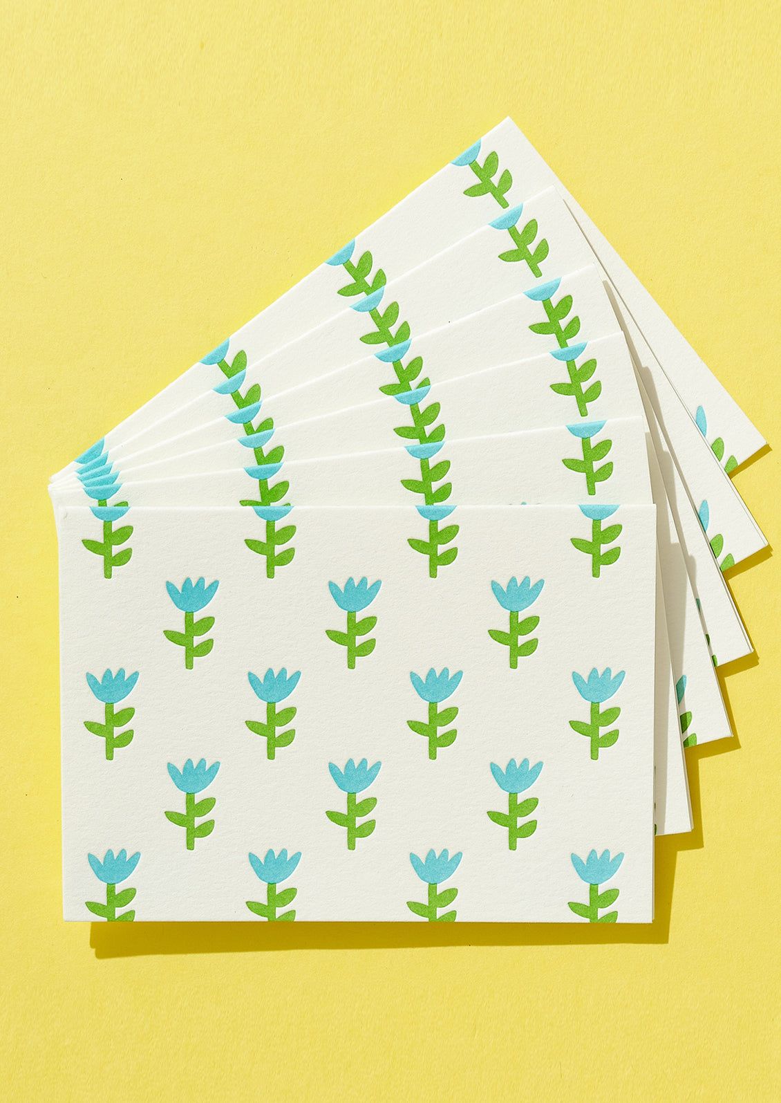 Stack of folded paper with floral pattern on a yellow background