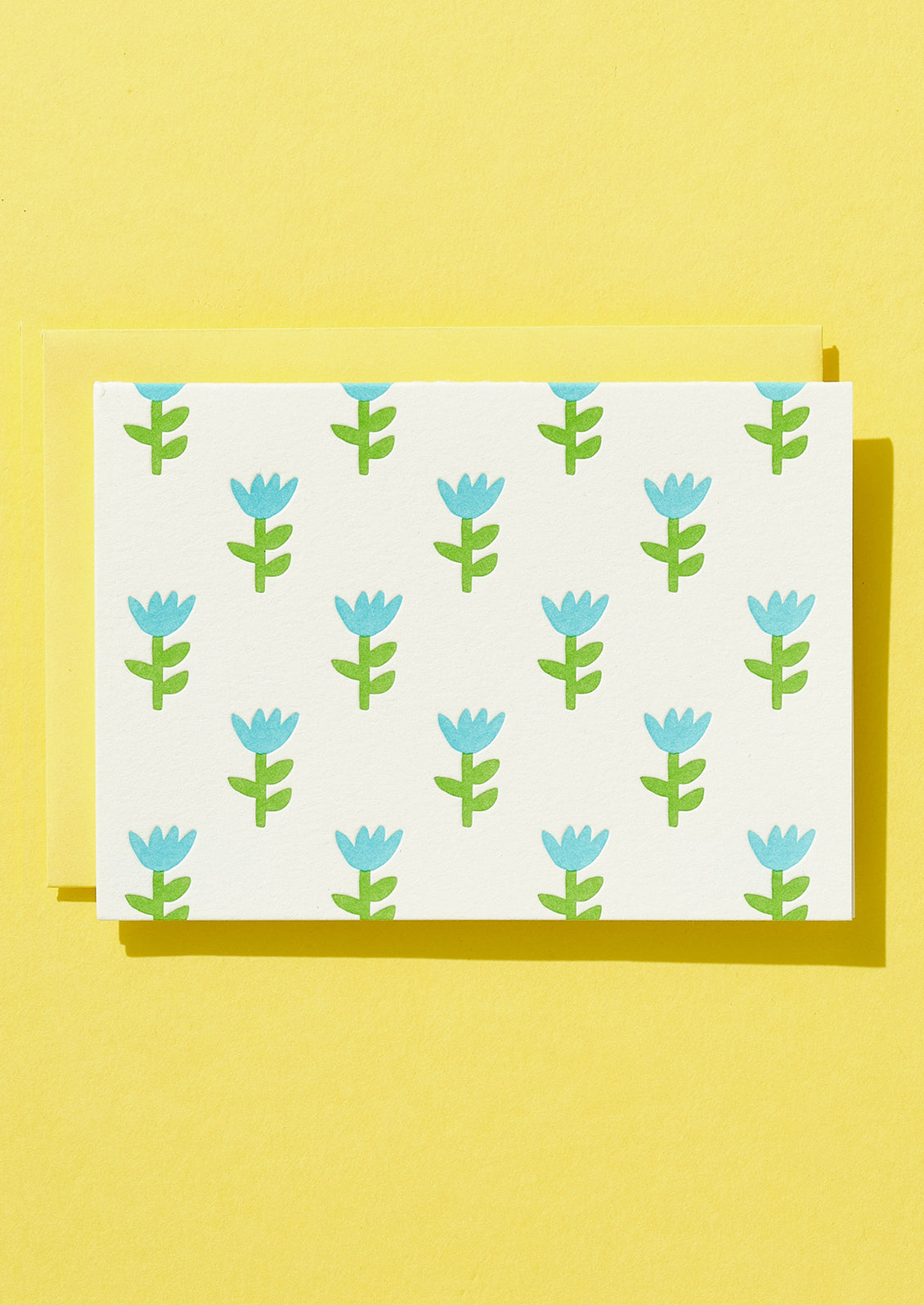 Patterned paper with blue and green floral design on a yellow background
