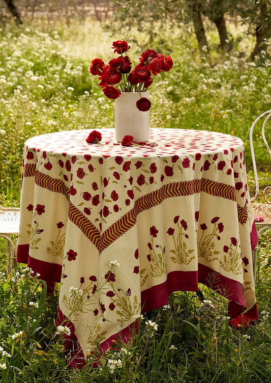 Round table with a floral tablecloth in a field of flowers