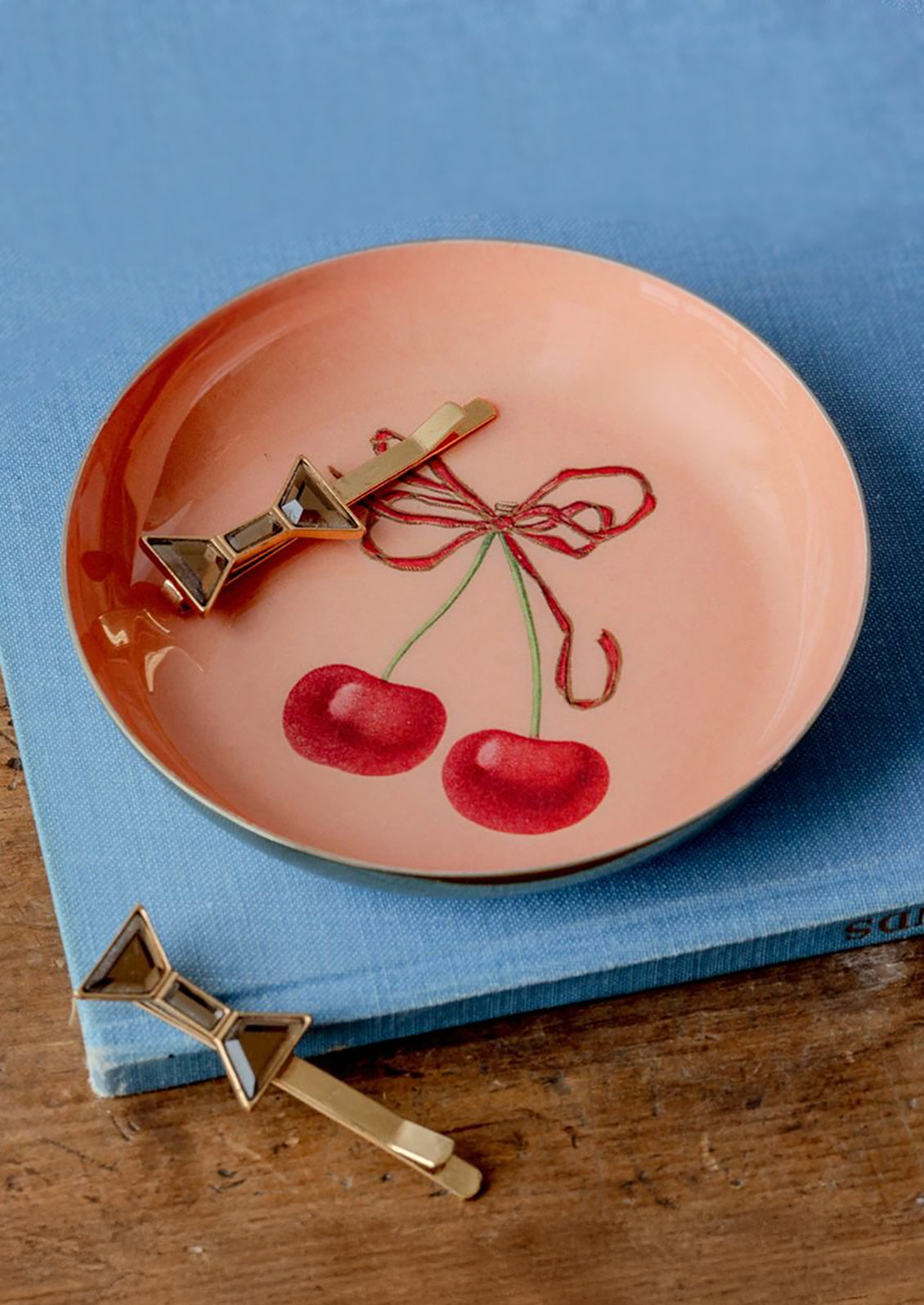 A round enamel trinket tray with cherry design.