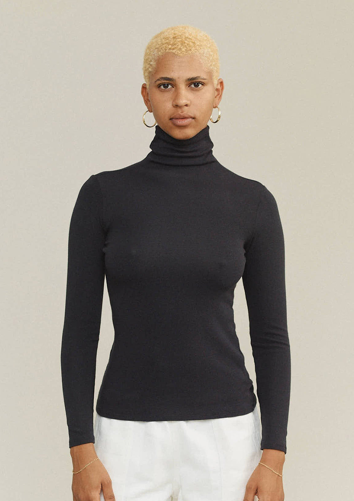 A woman wearing a turtleneck t-shirt in black.