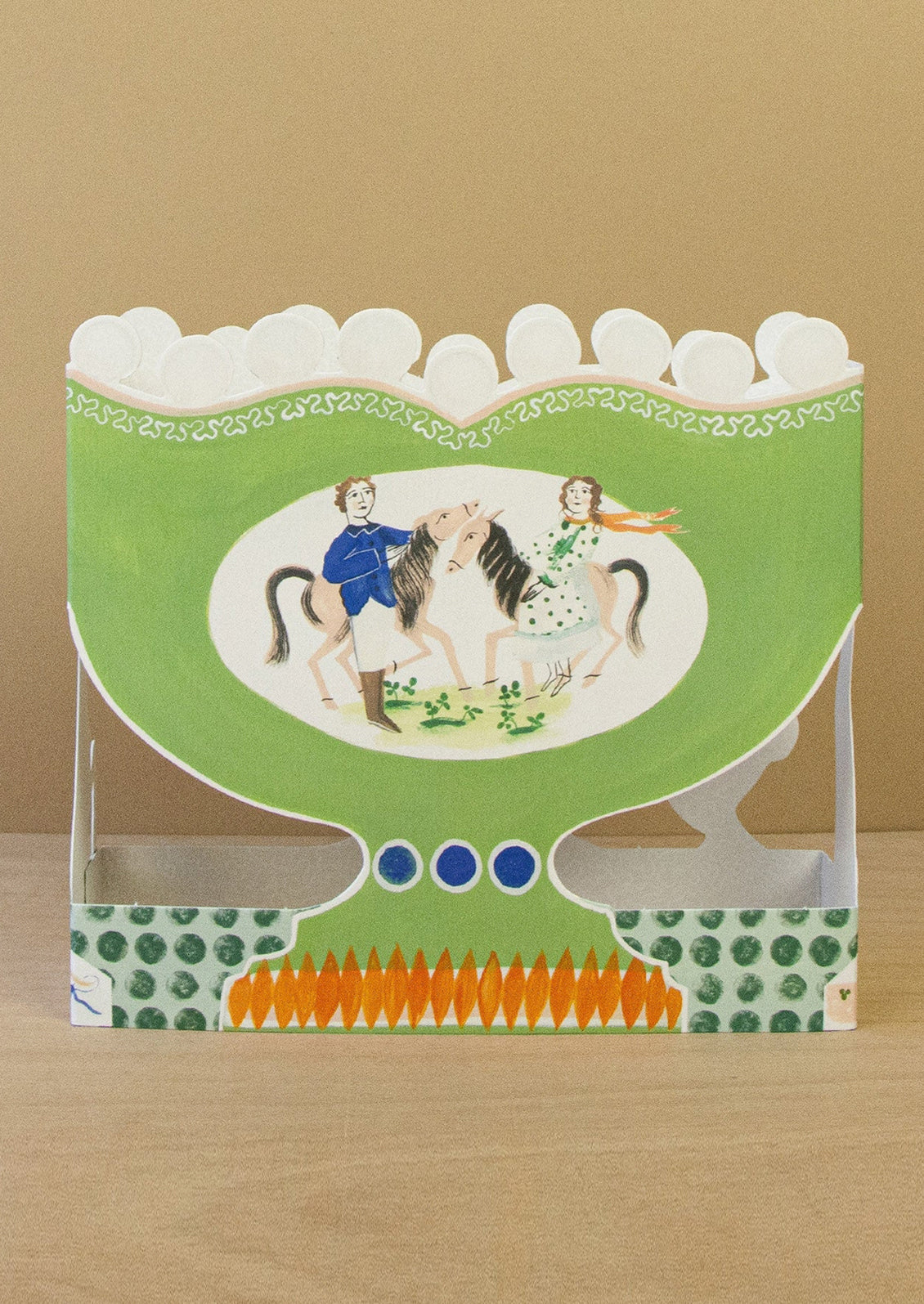 Decorative card with a green border featuring illustrations of people and horses on a brown background.