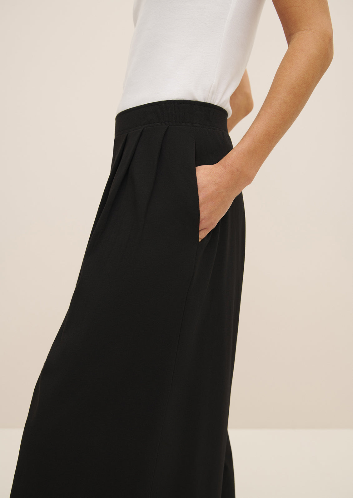 A woman wearing a pair of flowy, wide leg black pants.