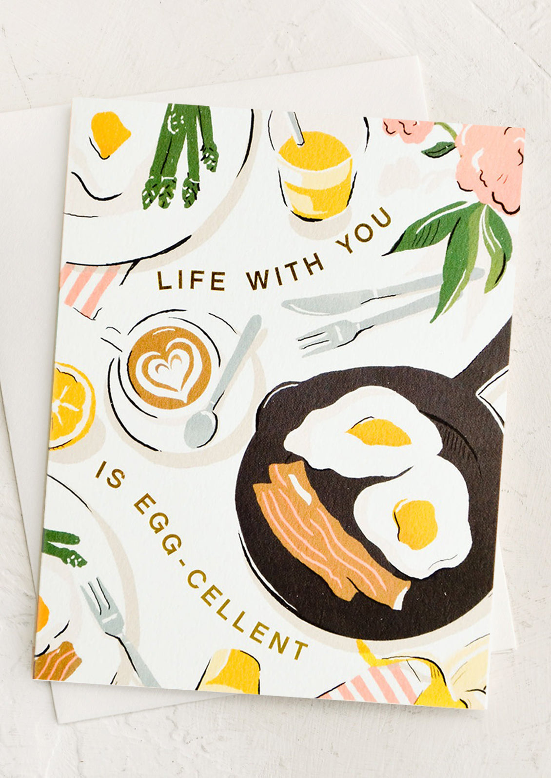 Greeting card with breakfast scene and gold letters reading "Life with you is egg-cellent"