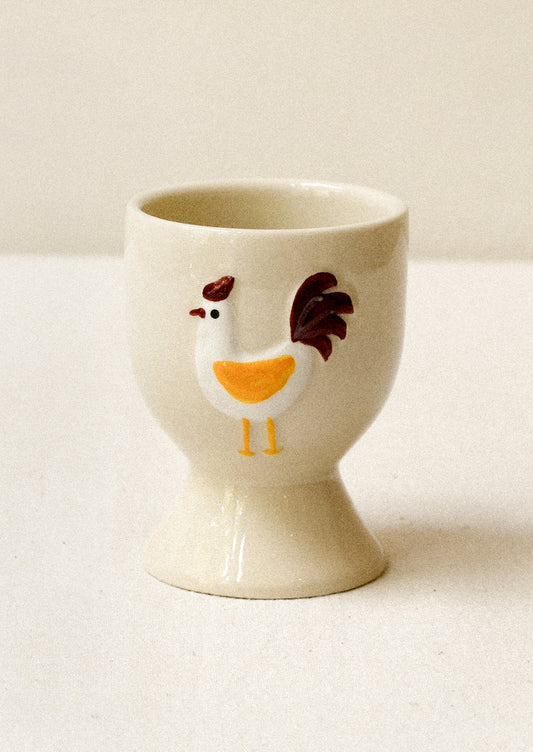 Ceramic egg cup with a chicken design on a white surface
