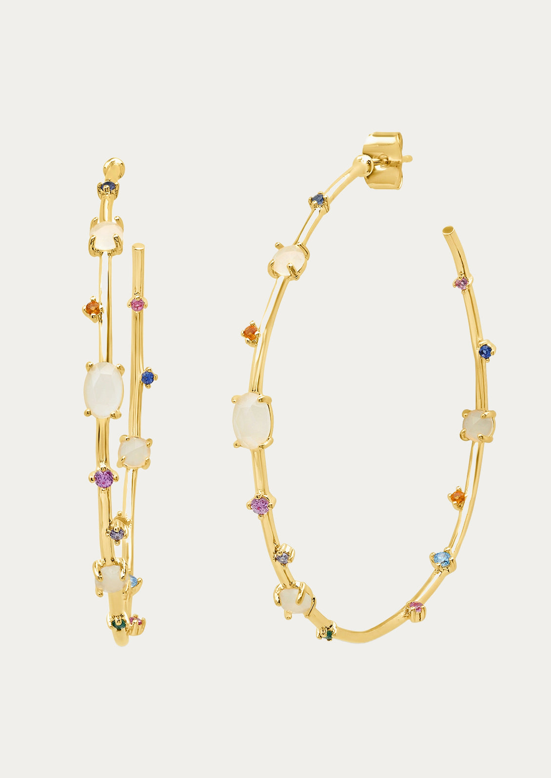 A pair of large gold hoops adorned with various colored jewels.