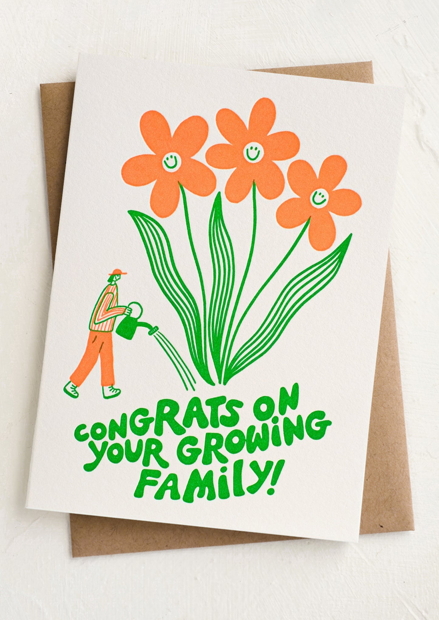Greeting card with orange flowers and a person watering plants, featuring the text 'Congrats on your growing family!'.