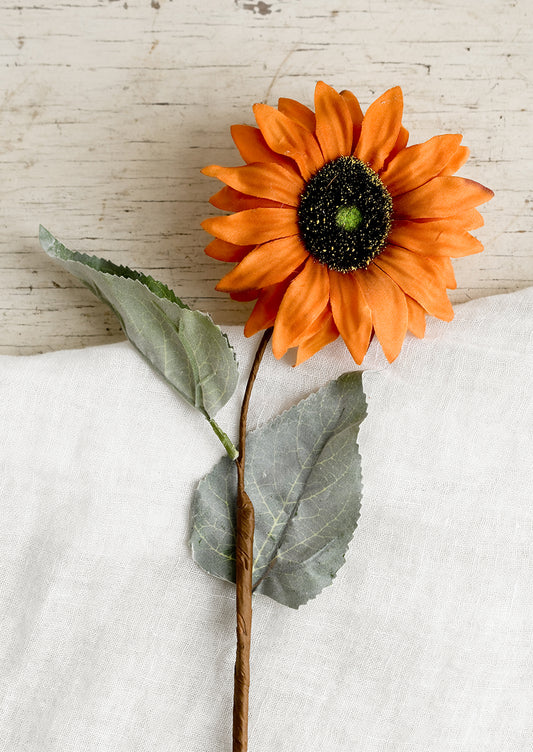 A faux orange sunflower stem.