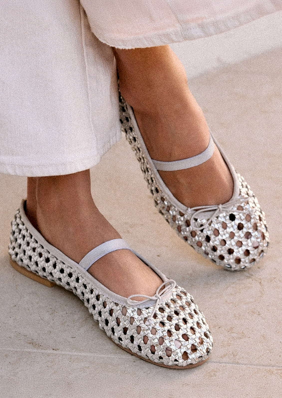 A pair of open weave leather ballet flats in silver.
