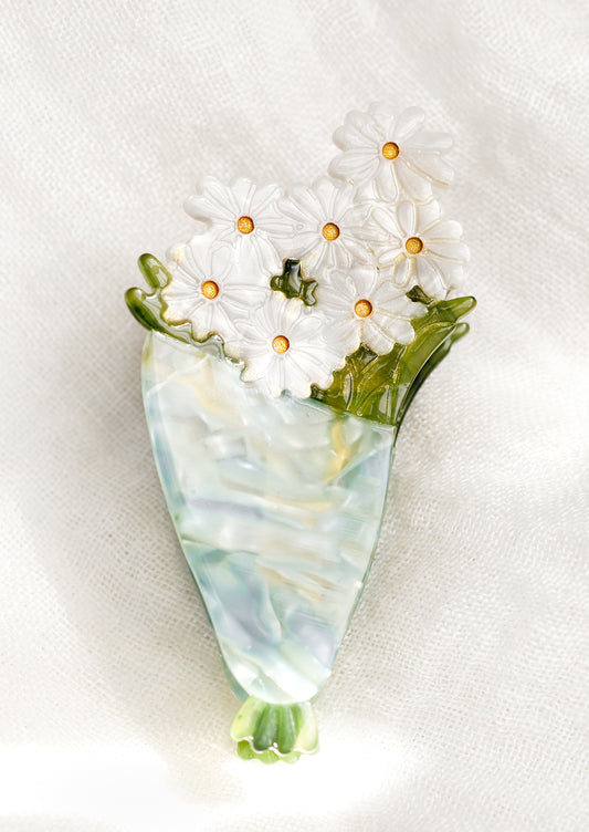 A detailed hair claw depicting a bouquet of daisies.