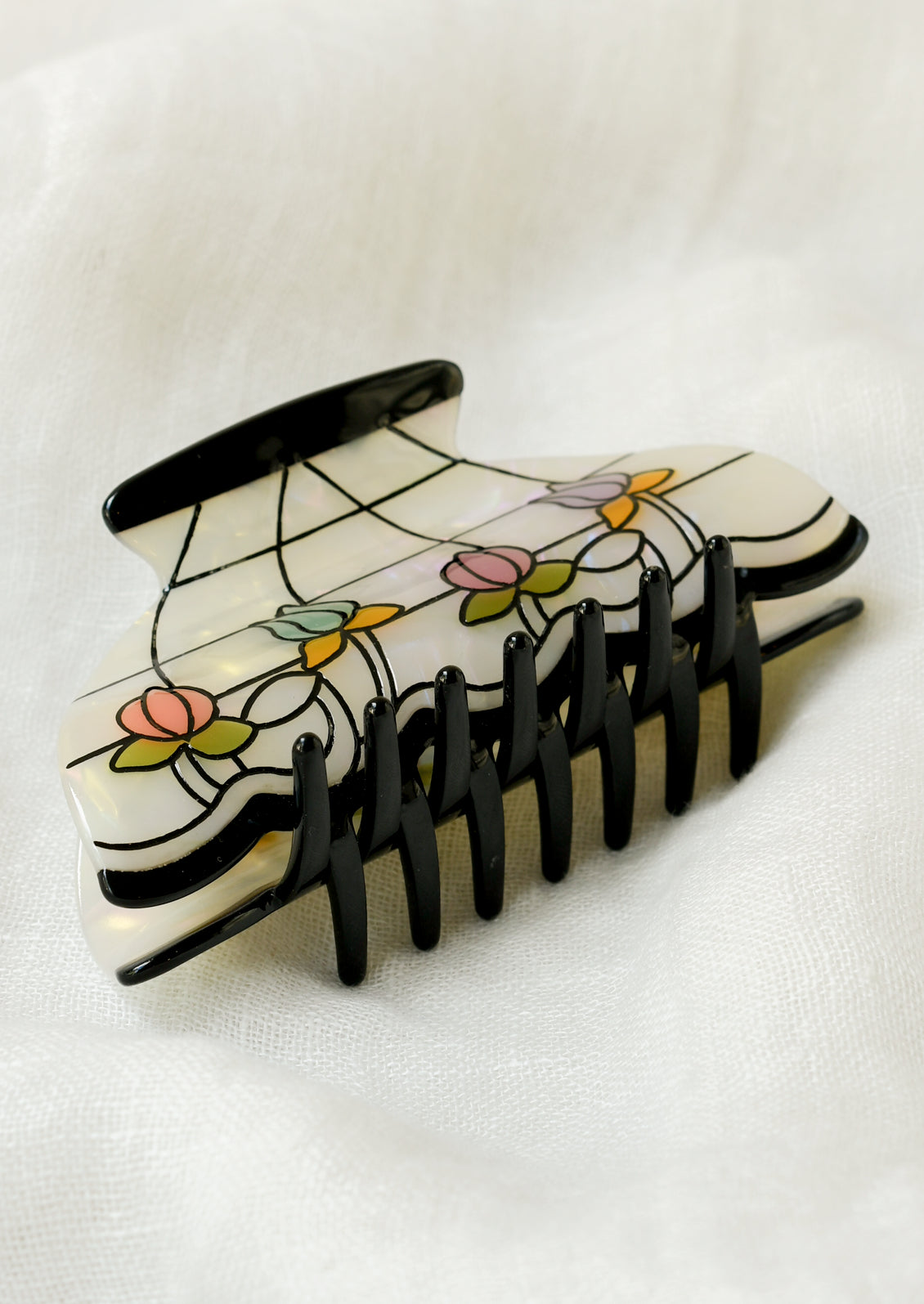 A hair claw shaped like a lamp shade with colorful florals and a grid pattern.