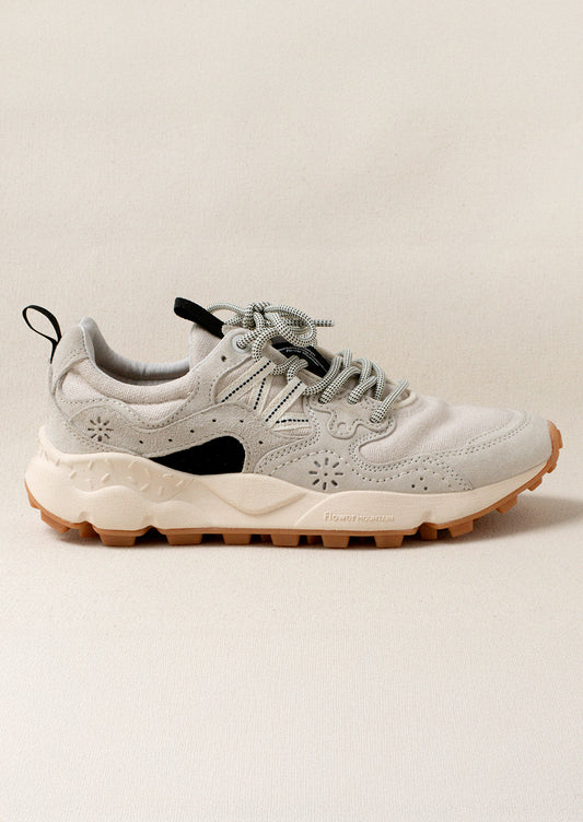 A pair of sporty sneakers in neutral colors with flower cutout detailing.