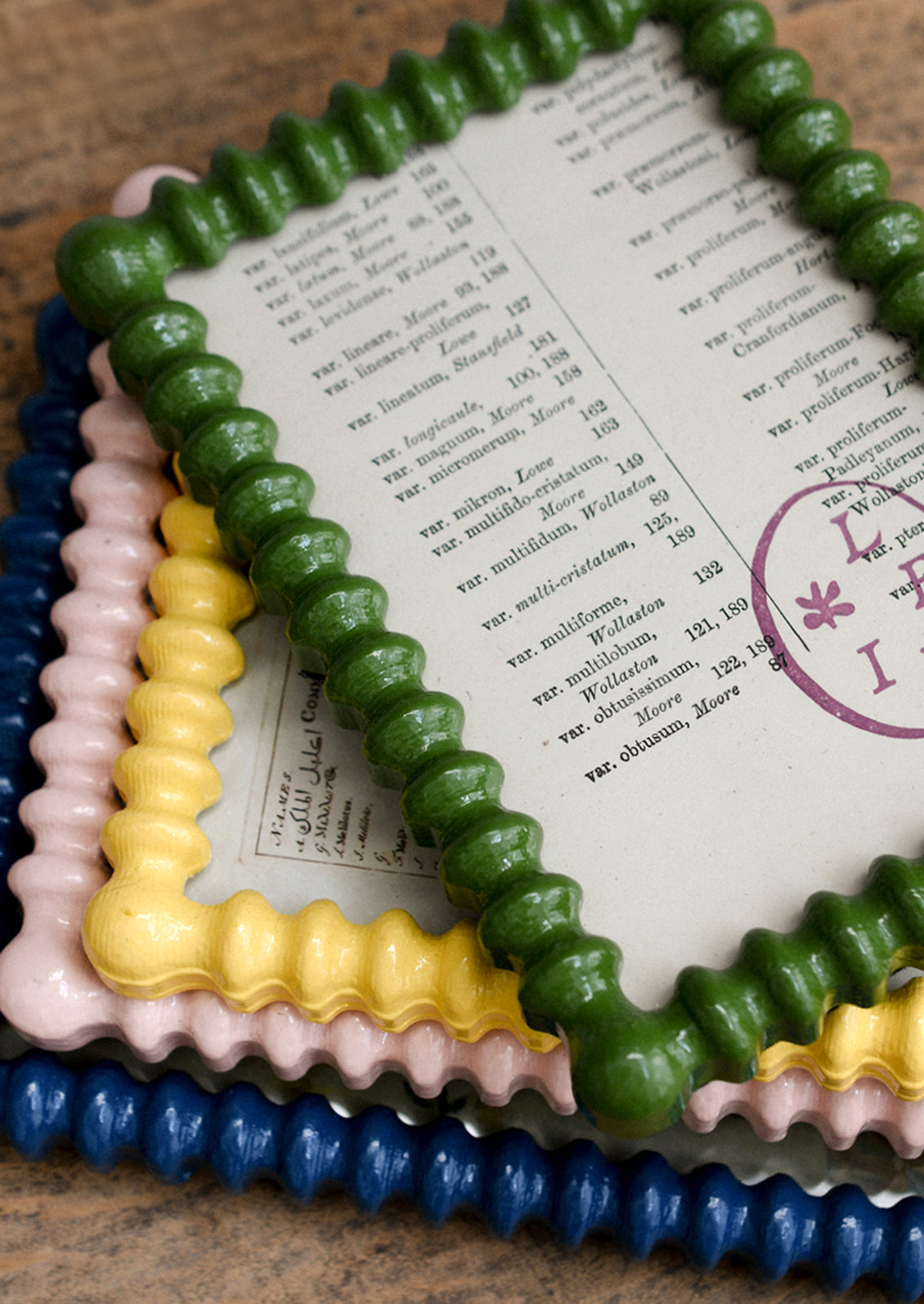 Assorted high gloss picture frames with barbed hobnail shape in a mix of colors.