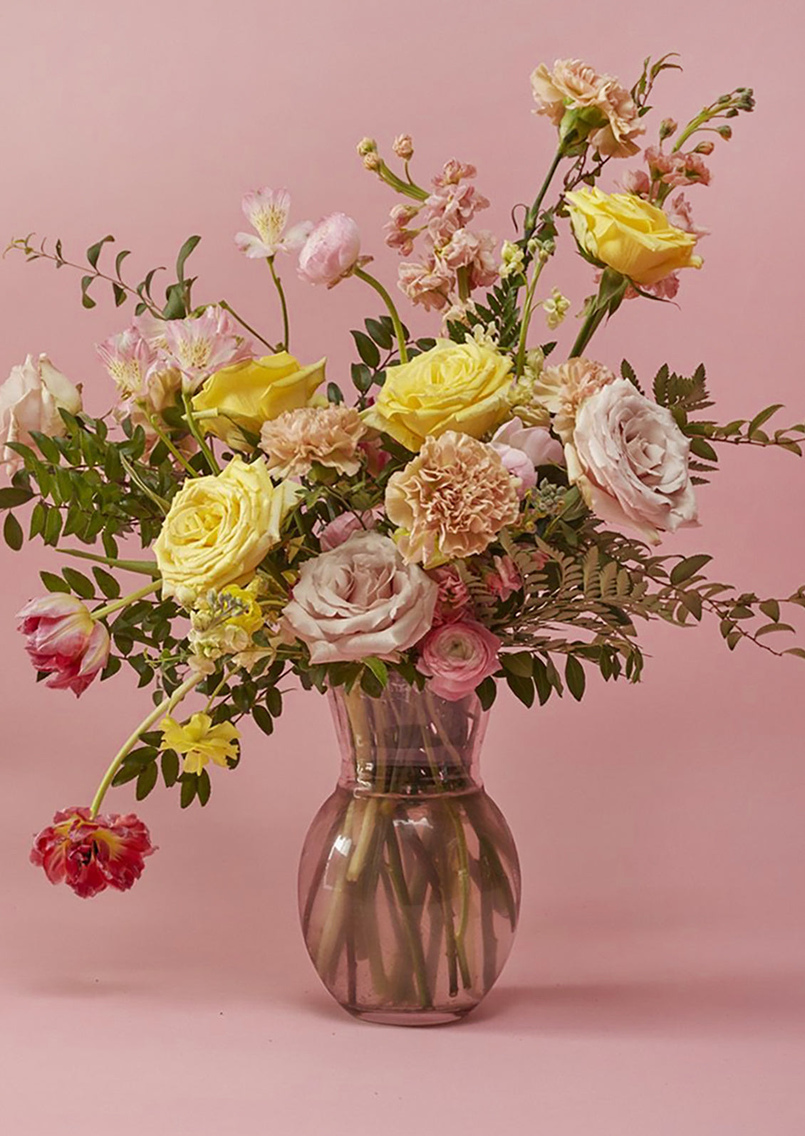 A pink tinted glass vase with pinched shape.