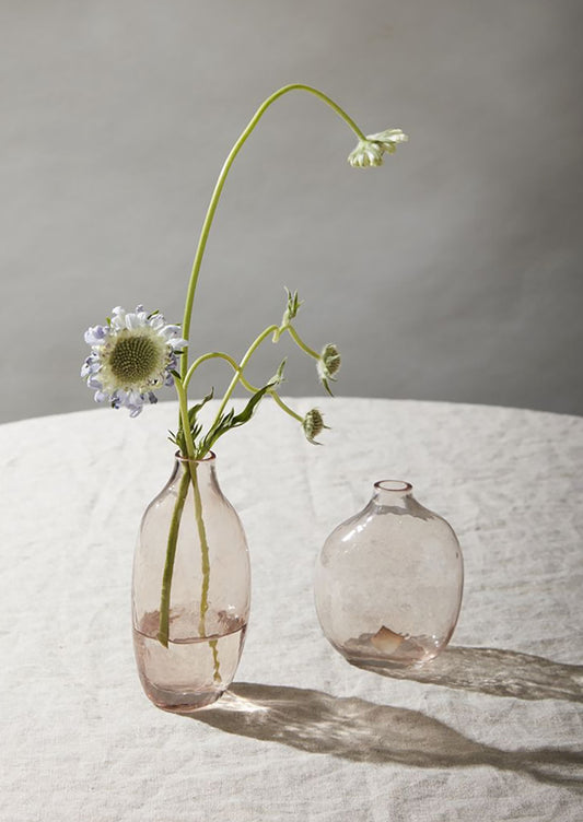 Clear pink glass bud vases in short and tall sizes.