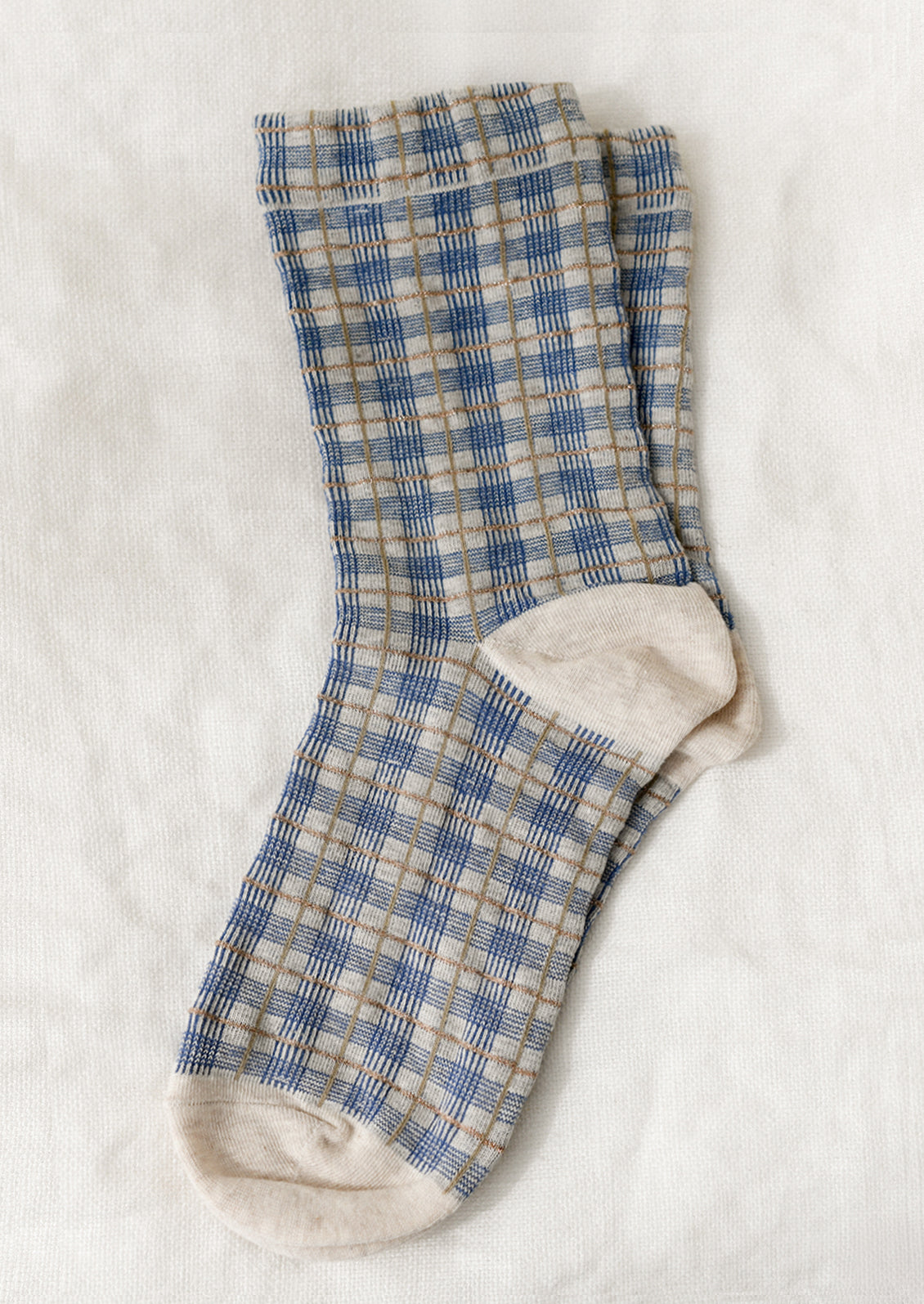A pair of socks with blue and gold plaid pattern.