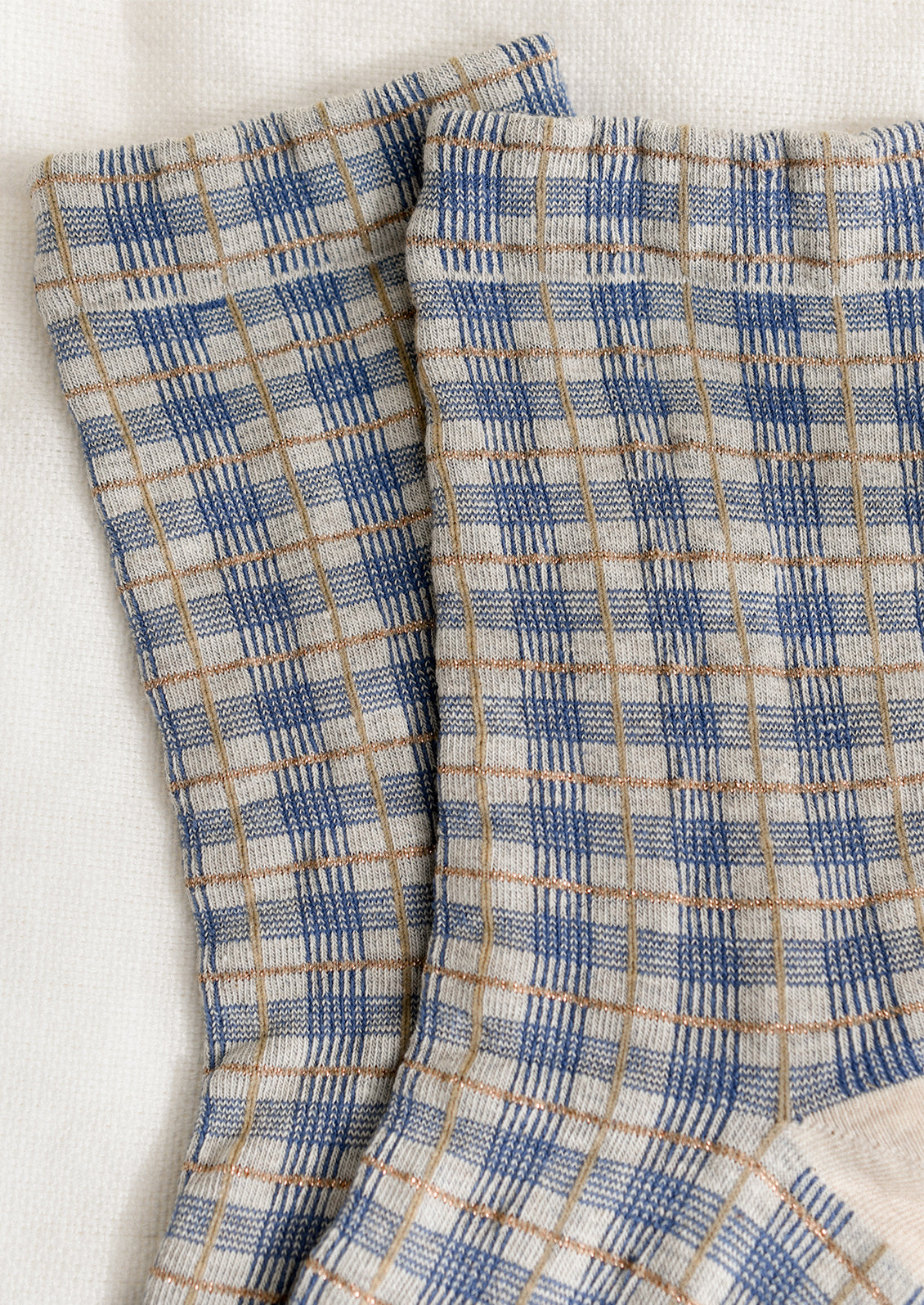 A pair of socks with blue and gold plaid pattern.
