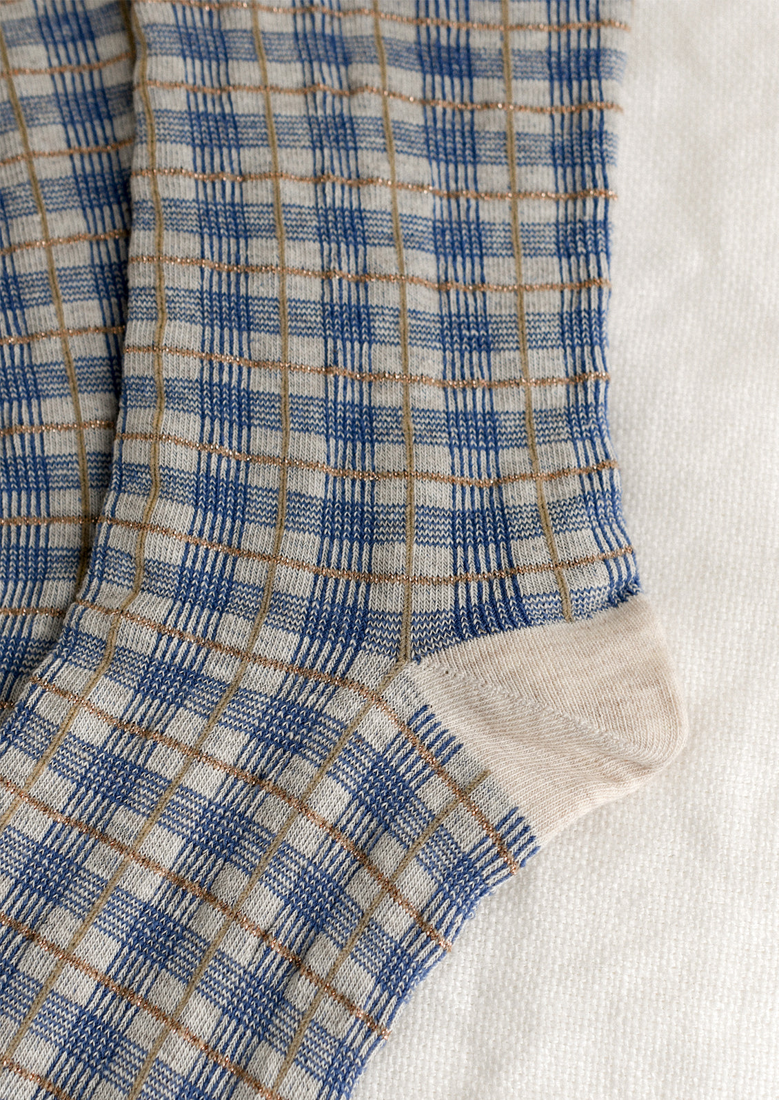 A pair of socks with blue and gold plaid pattern.