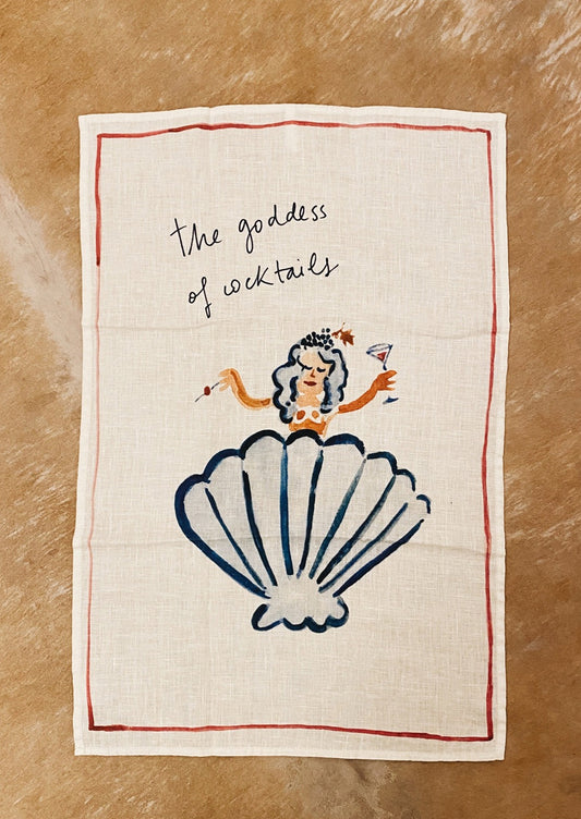 A white linen tea towel with Goddess of Cocktail graphic and text.