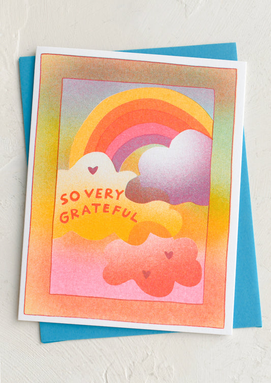 Colorful greeting card with rainbow and clouds and 'So Very Grateful' text on a white background.