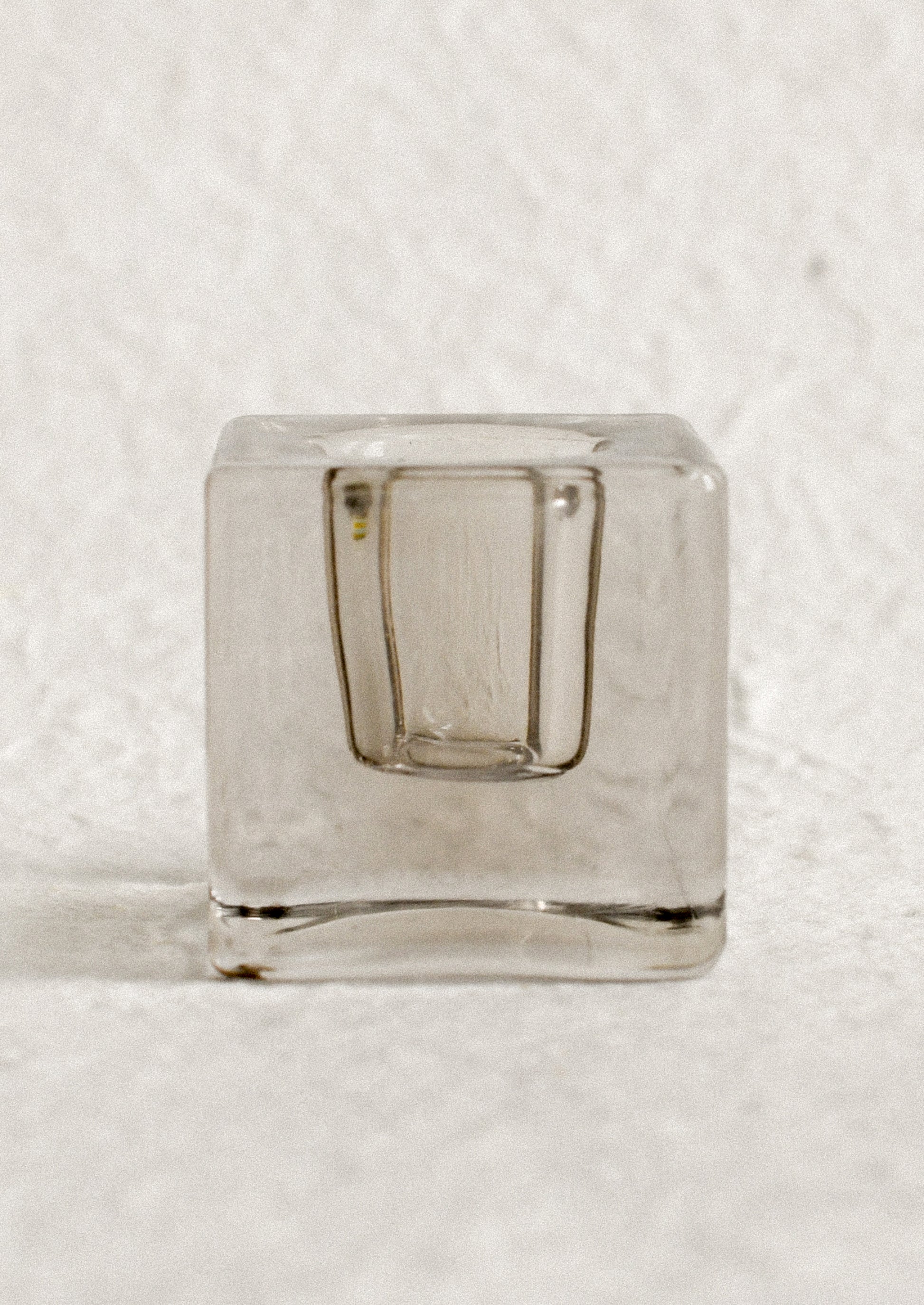 A cube-shaped slab glass candleholder in grey / short.