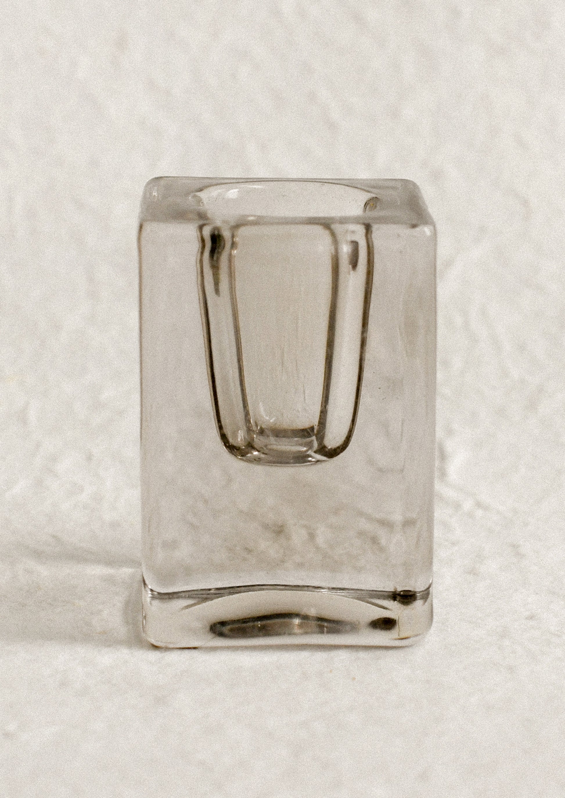 A cube-shaped slab glass candleholder in grey / tall.