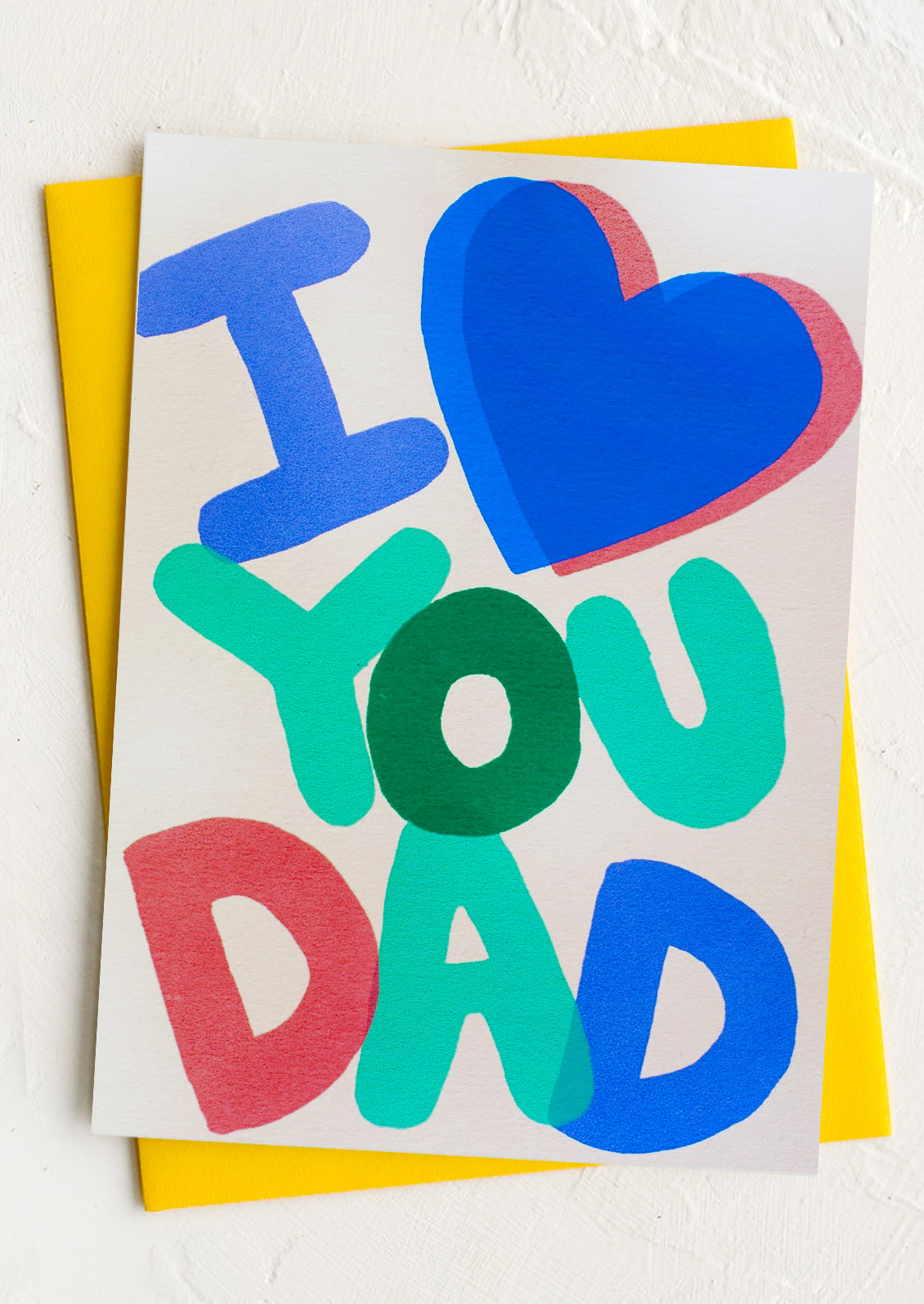 A greeting card with colorful bubble letters reading "I <3 You Dad"