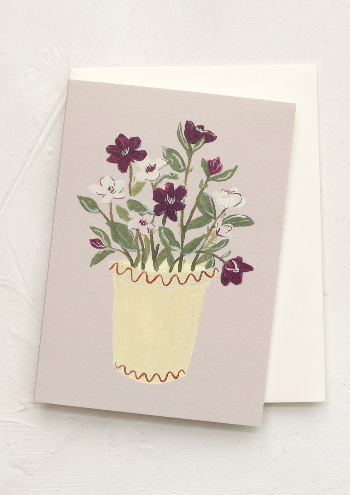 A mini greeting card in mauve with illustration of hellebores in pot.