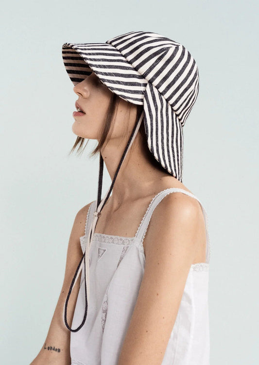 Person wearing a black and white striped hat on a light gray background