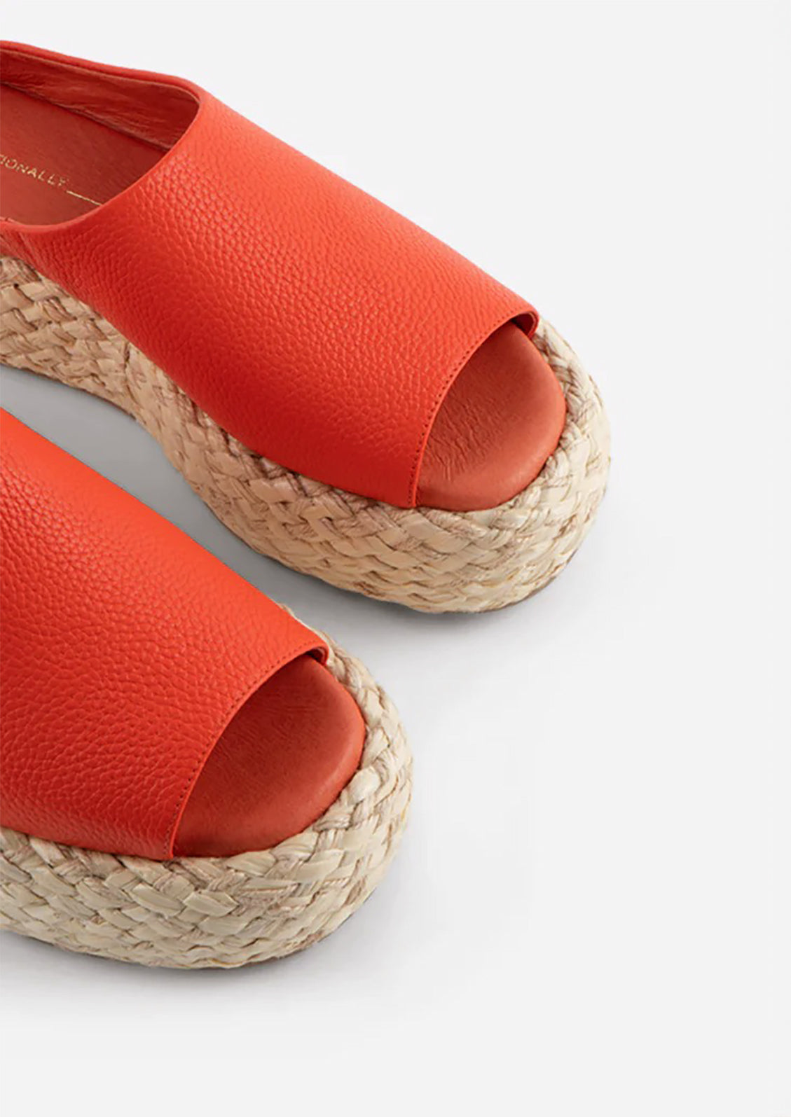 A pair of leather platform sandals with espadrille sole in poppy red-orange.