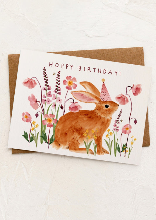 Birthday card with a rabbit and flowers on a white background