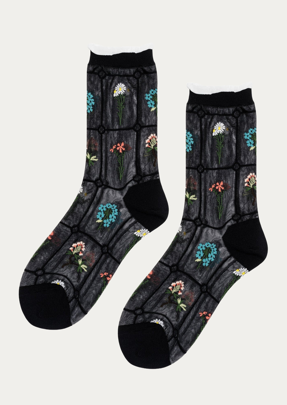 A pair of semi-sheer black socks with various embroidered flowers.