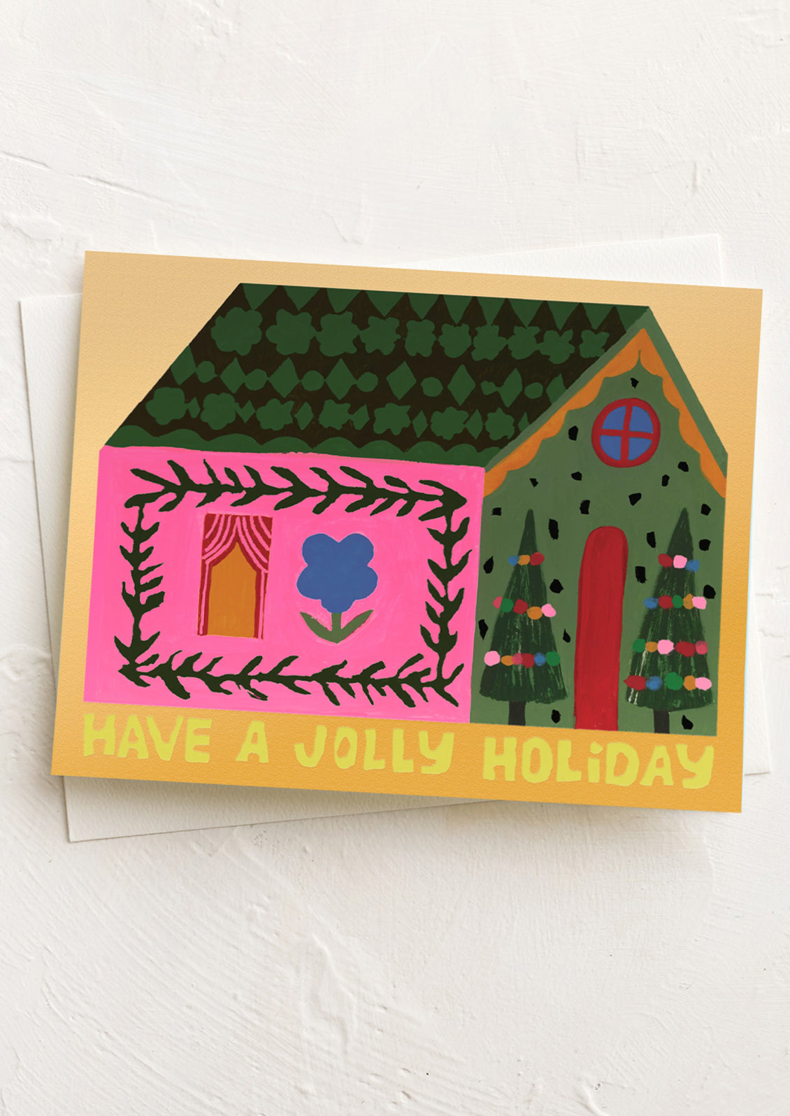 A greeting card with image of neon pink house, text reads "Have a Jolly Holiday".