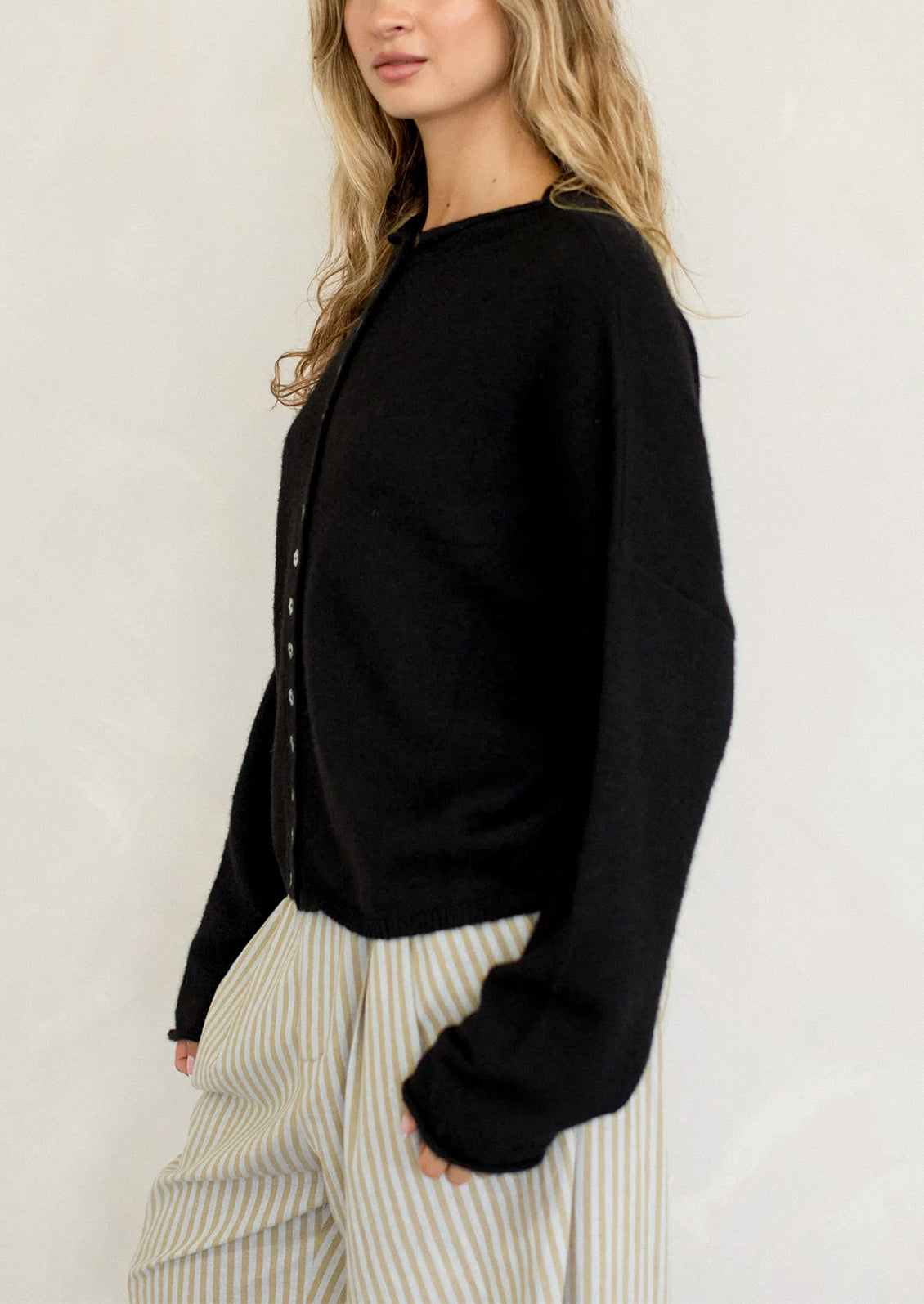 Woman wearing a black long-sleeve top with a white background