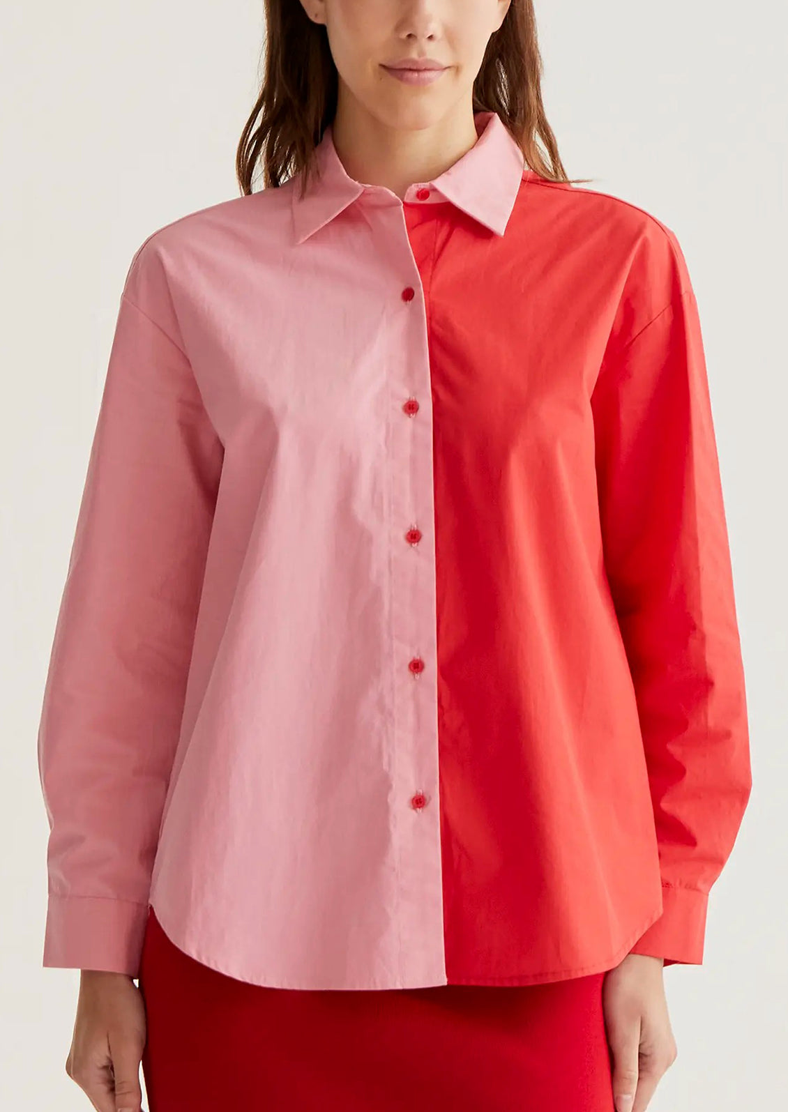Two-tone pink and red shirt worn by a person on a white background