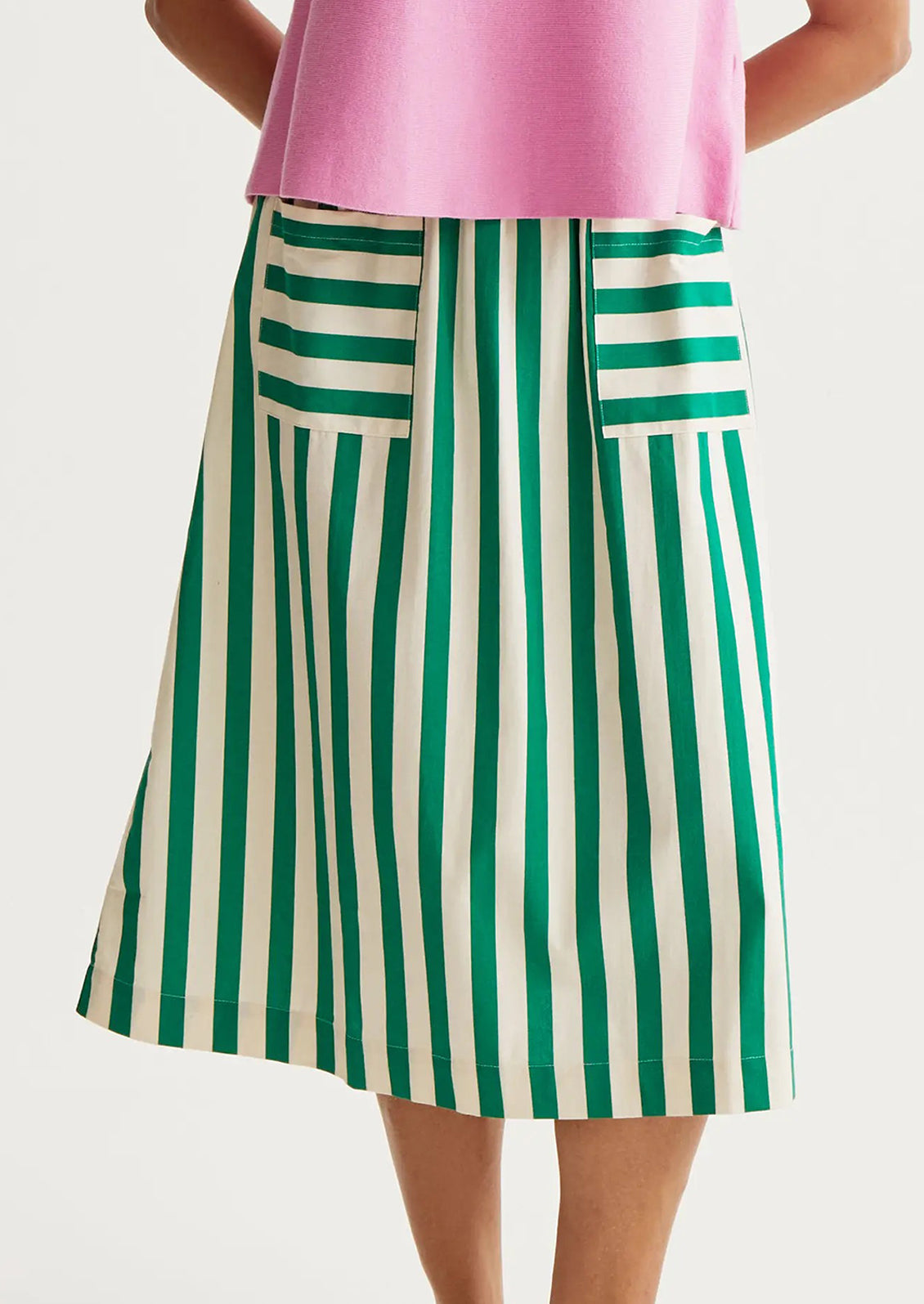 Green and white striped skirt worn by a person on a light gray background